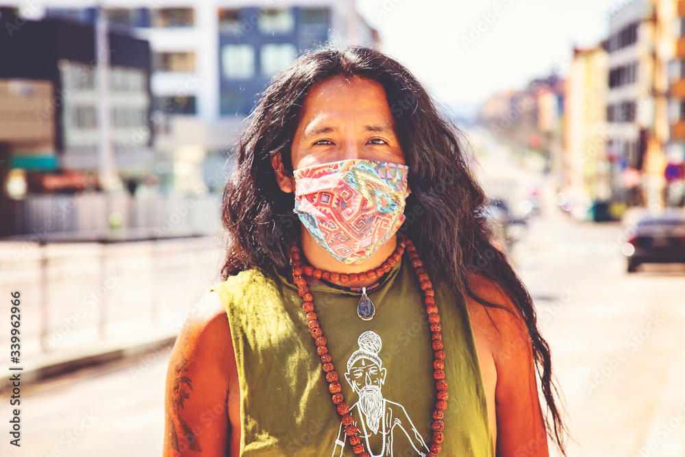 Man with long hair wearing protective face mask in the city