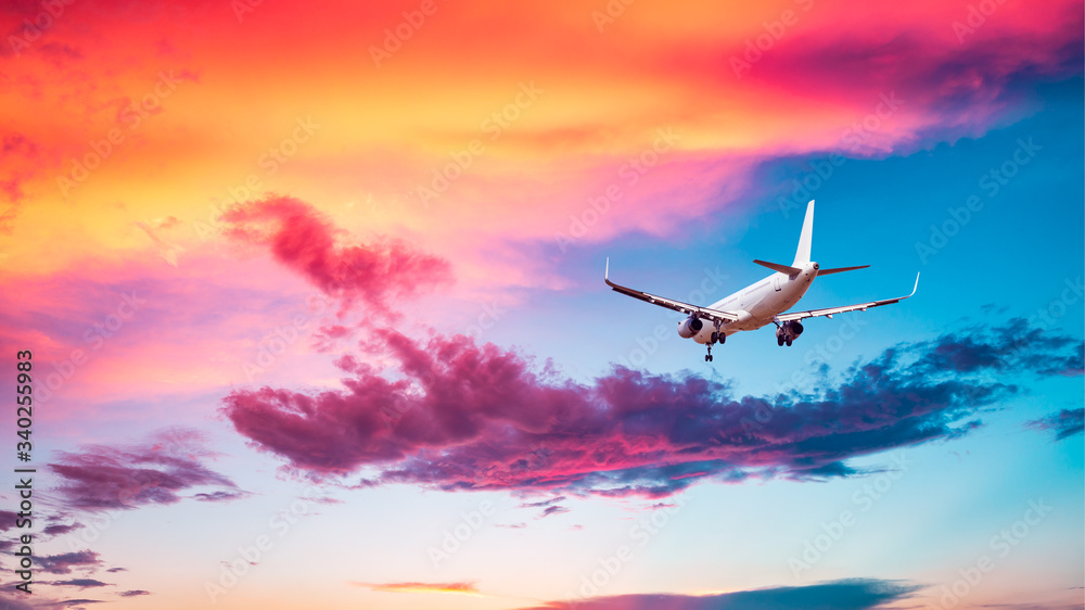 Commercial airplane flying in beautiful sky at sunset,travel concept.