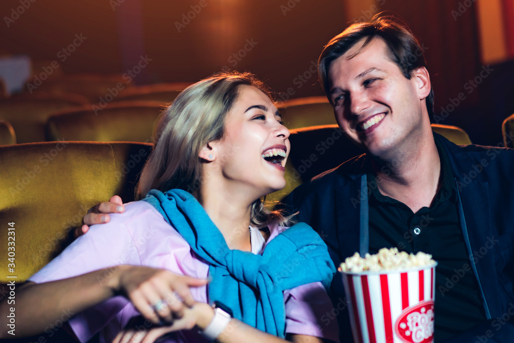 Caucasian lover enjoying to watch movie and eating popcorn together in the cinema