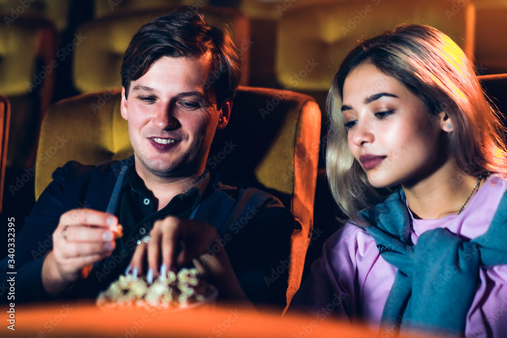 Caucasian lover enjoying to watch movie and eating popcorn together in the cinema