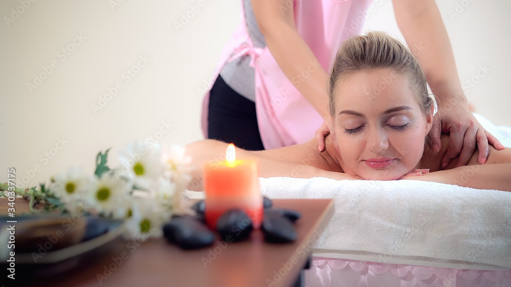 Relaxed woman getting back massage in luxury spa with professional massage therapist. Wellness, heal