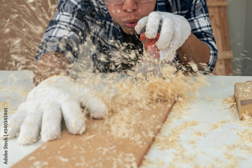 在车间里从事木制品生产建筑材料或木制家具的木匠。Th