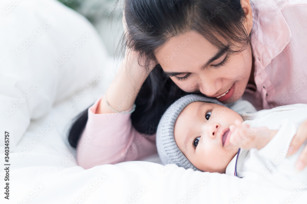 美丽的亚洲母亲和她快乐可爱的新生男婴的特写。母亲抱着bab