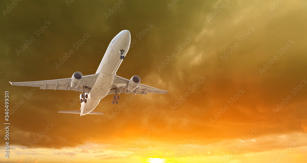 Commercial airplane flying in beautiful sky at sunset,travel concept.