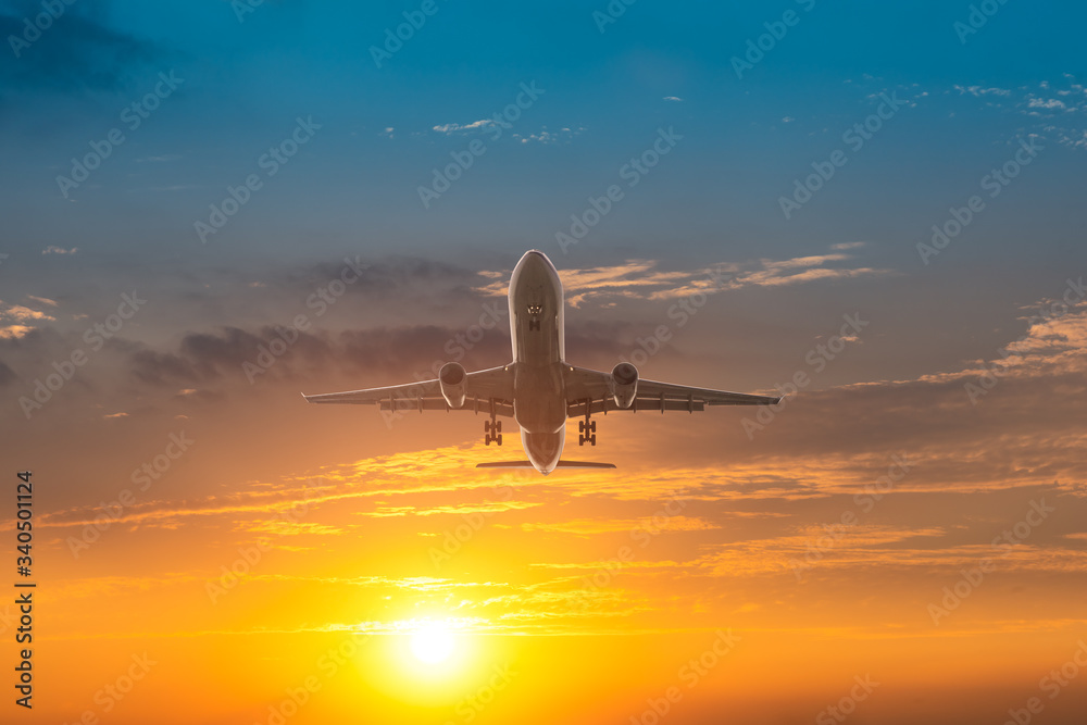 Commercial airplane flying in beautiful sky at sunset,travel concept.