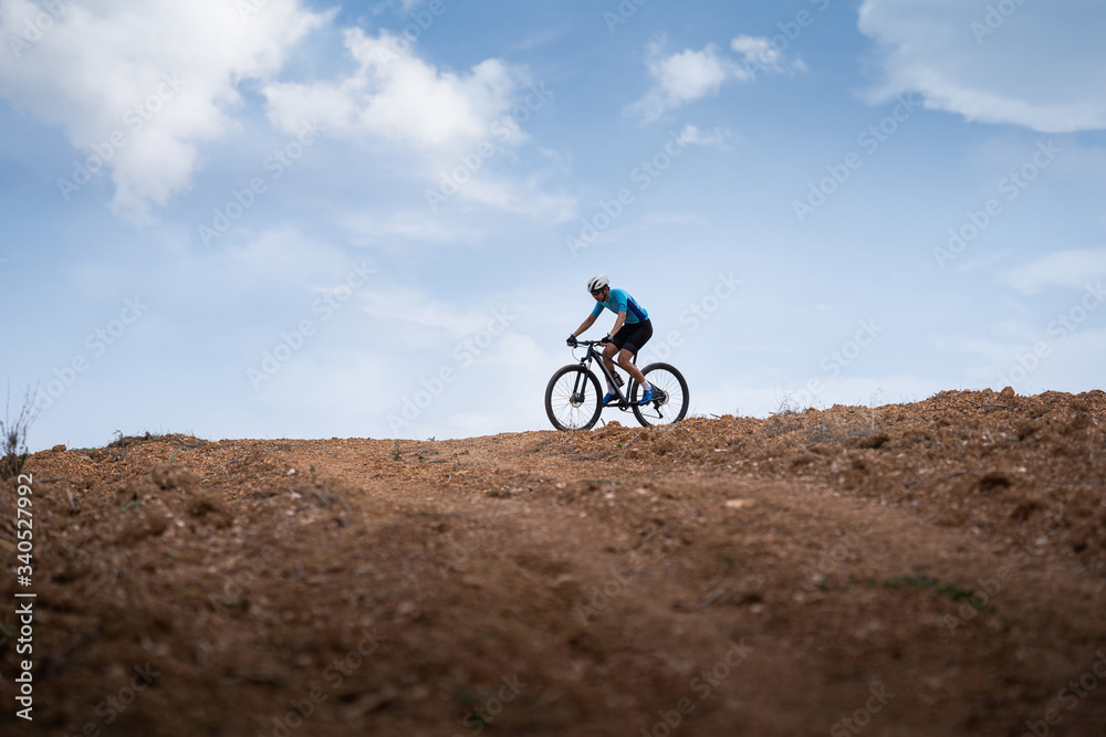 Mountain biker cycling, training and going up a steep climb.