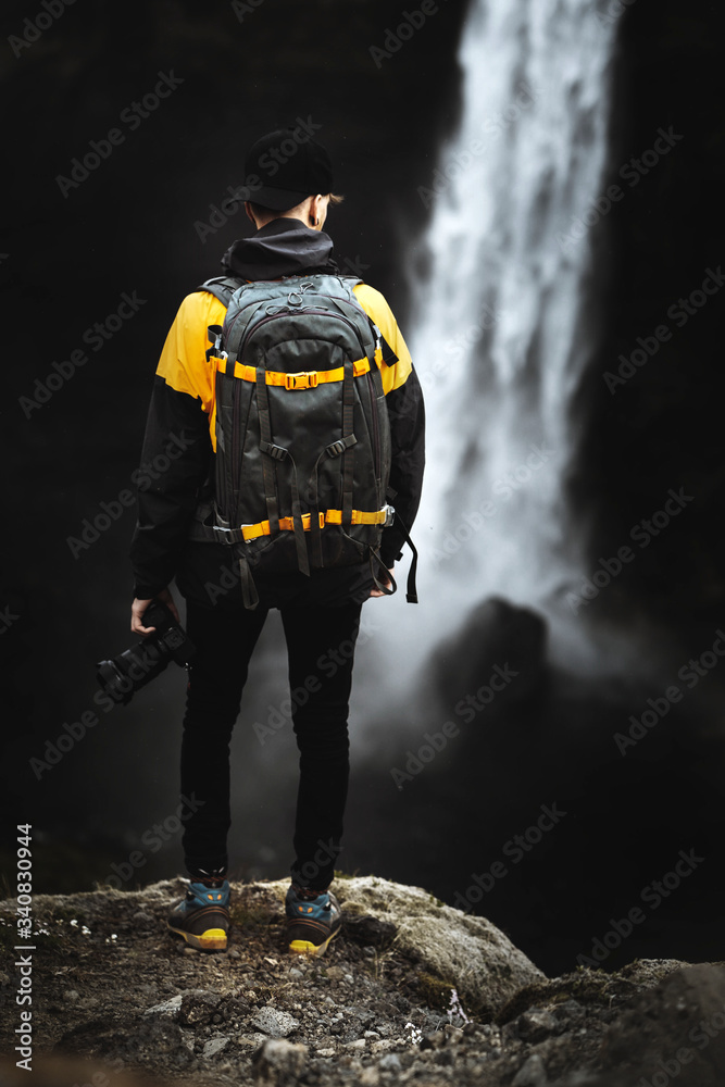 Traveler by a waterfall