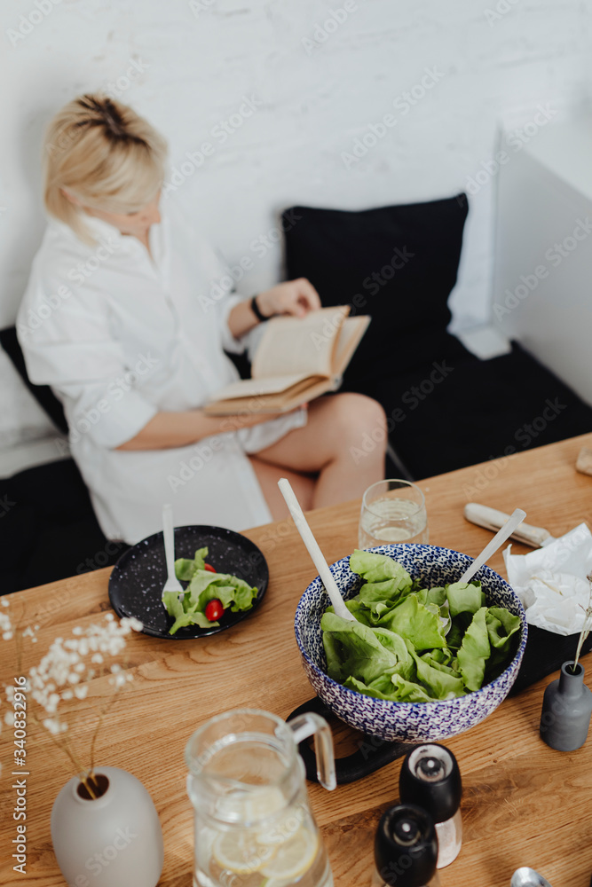 Woman reading a book at dinner