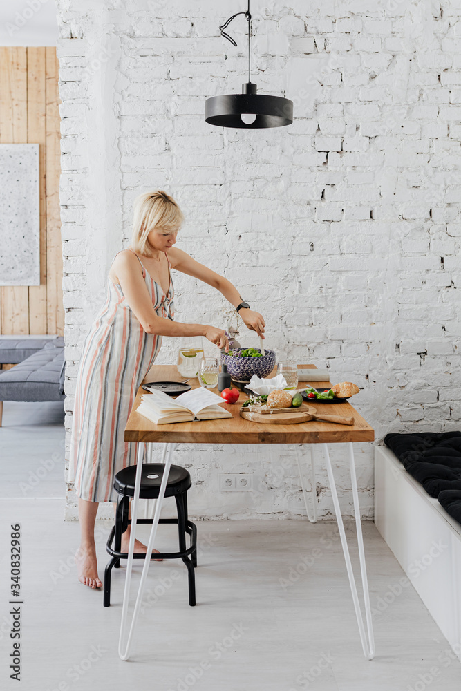 Pregnant woman cooking from a cookbook