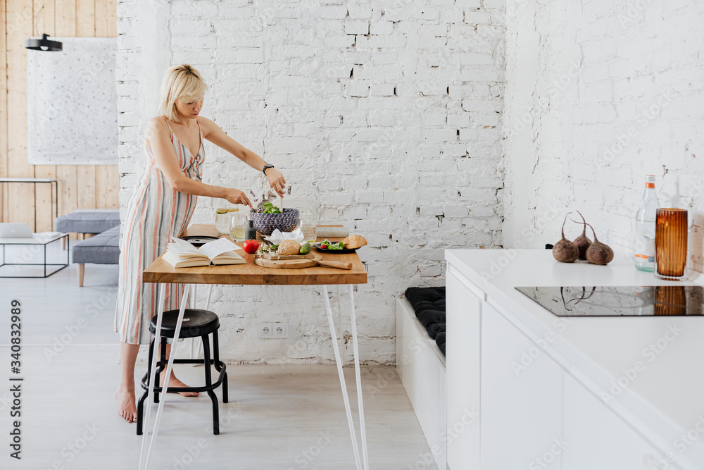 Pregnant woman cooking from a cookbook