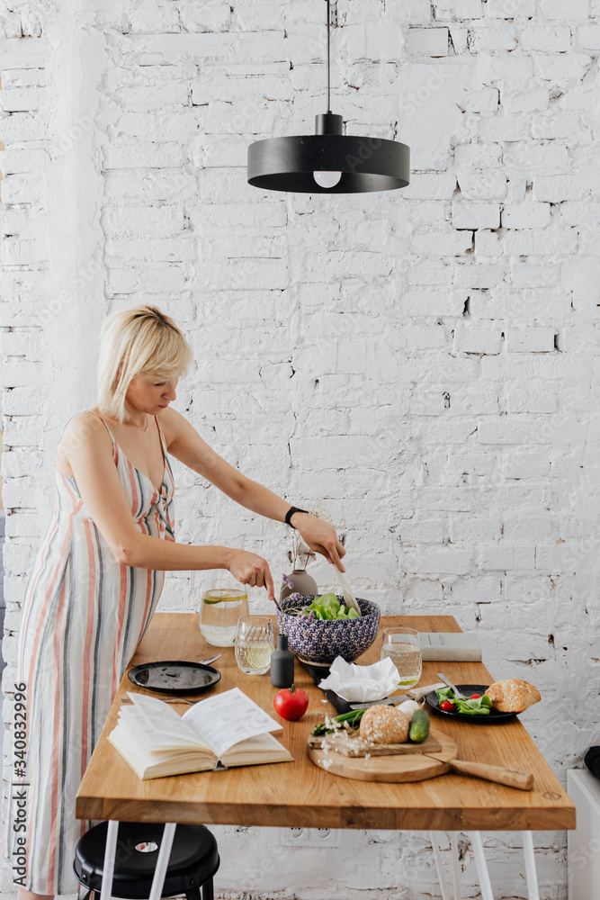 Pregnant woman cooking from a cookbook