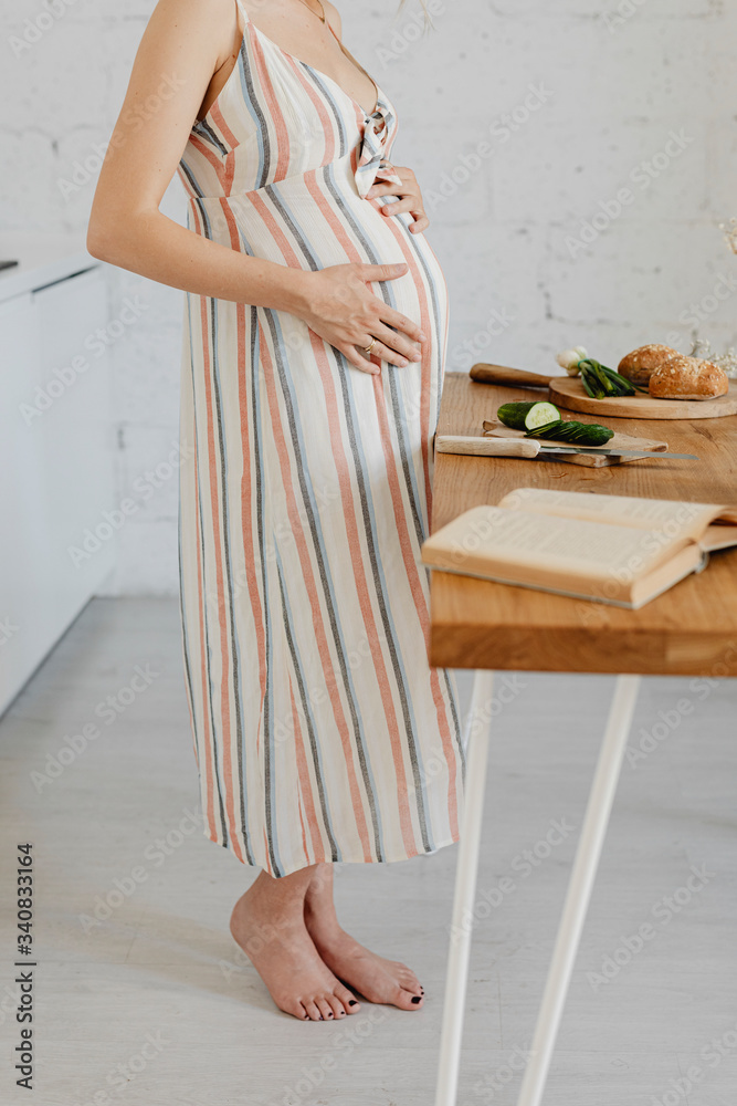 Pregnant woman cooking from a cookbook