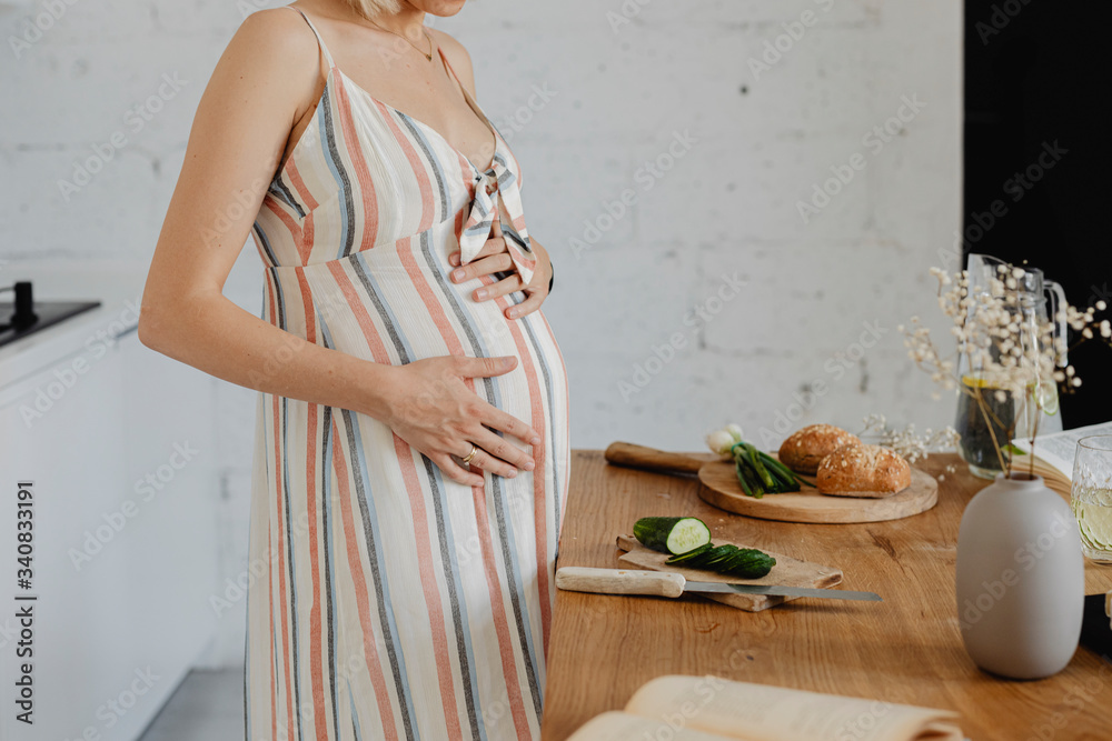 Pregnant woman cooking from a cookbook