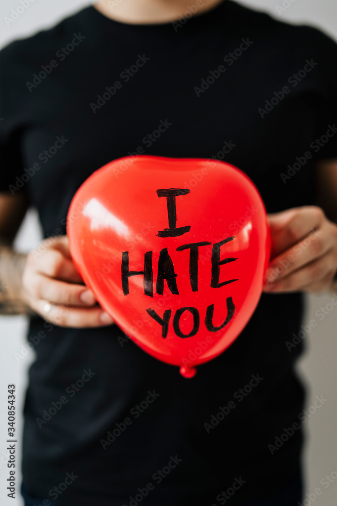 Man holding I Hate You balloon