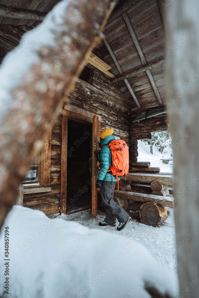 女摄影师走进雪地里的小屋