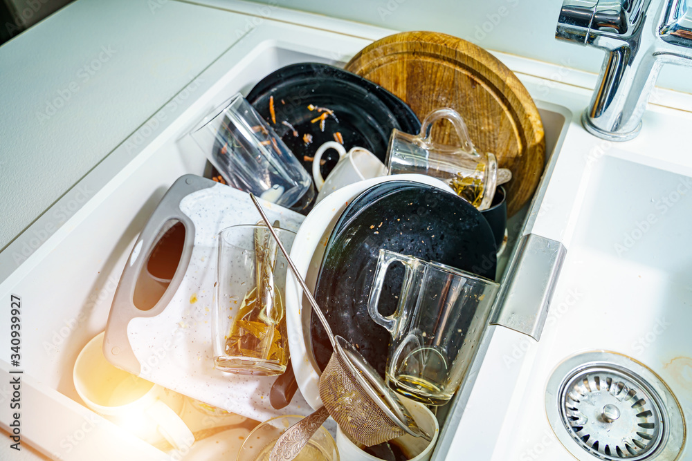 Kitchen sink with dirty dishes and utensils. Mess and sink. Dirty kitchen utensils.