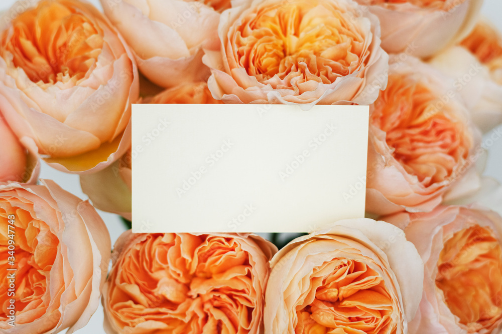 Wedding invitation on a bunch of orangeroses