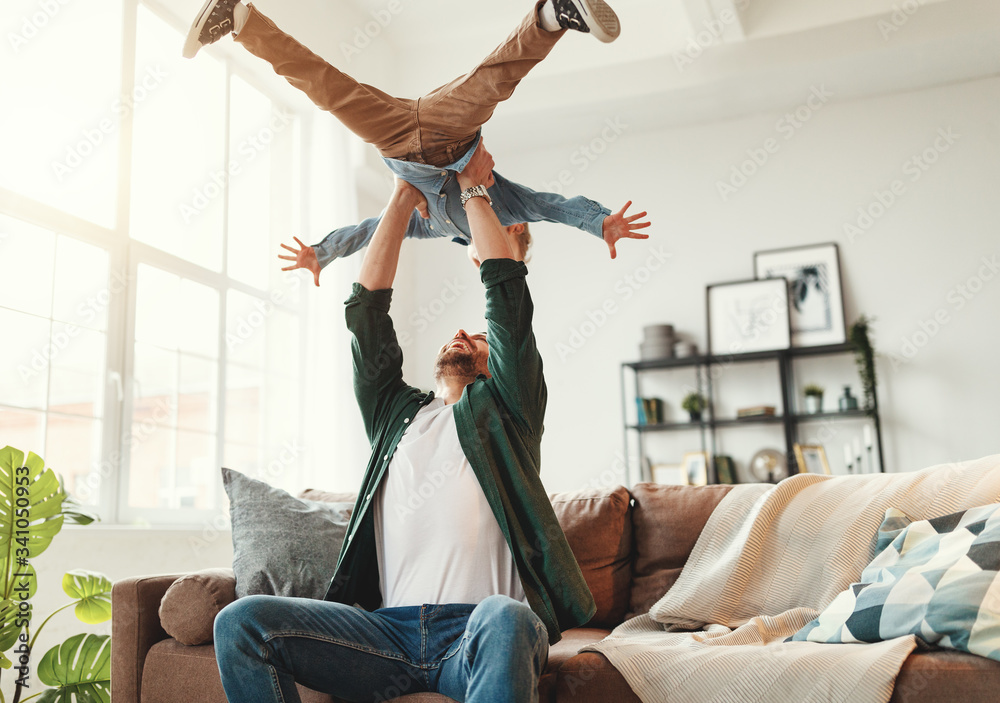 Happy man having fun with son at home.