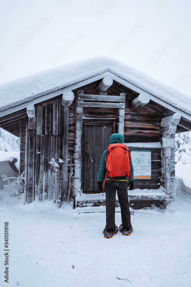 Woman standing in front of a snowy hut