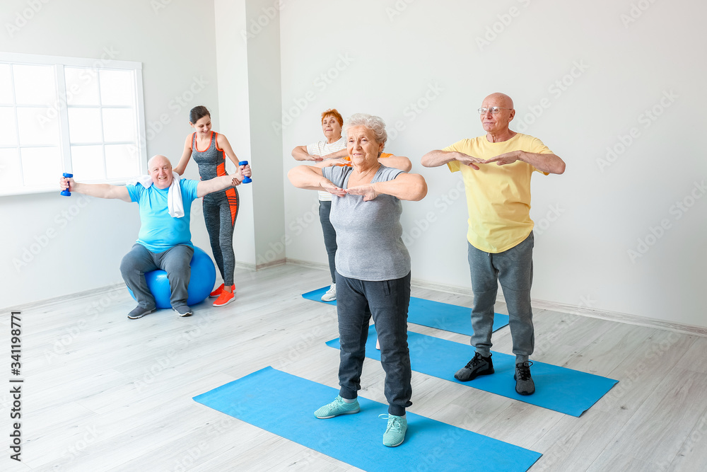 Elderly people exercising in gym