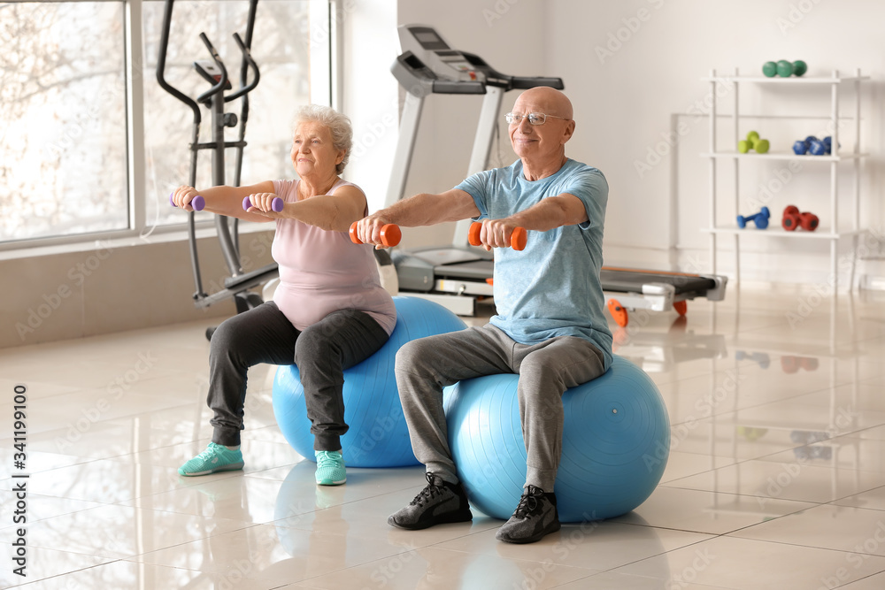 Elderly man and woman exercising in gym