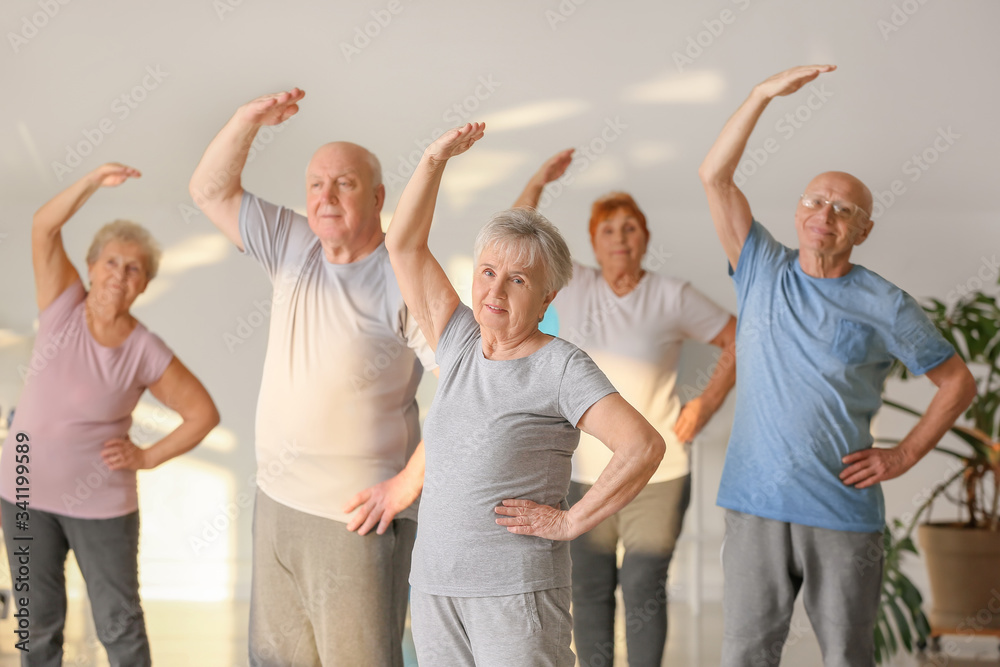 Elderly people exercising in gym