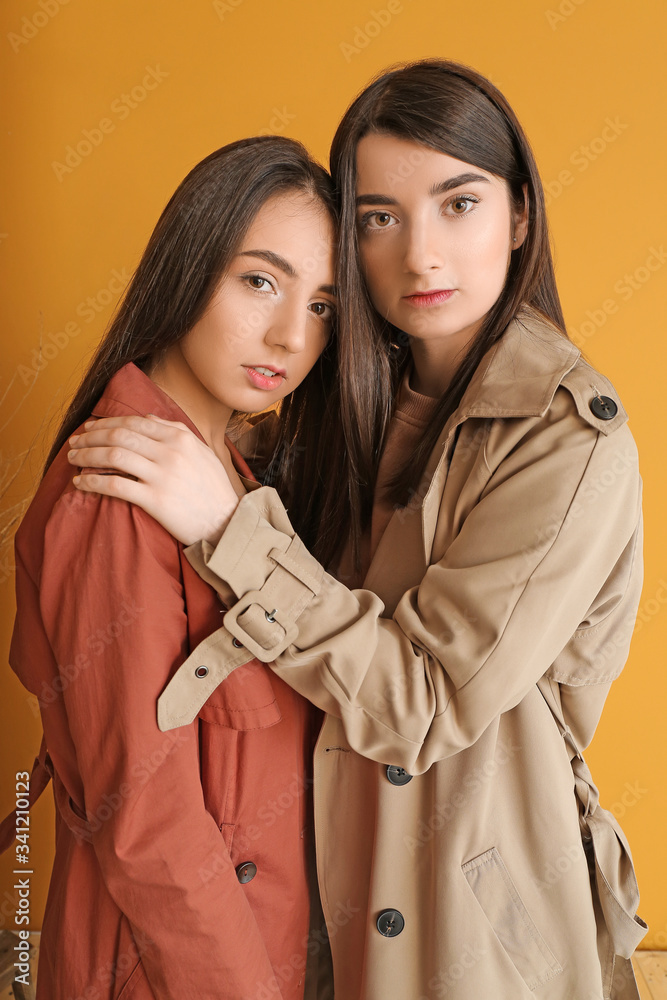 Stylish young women on color background