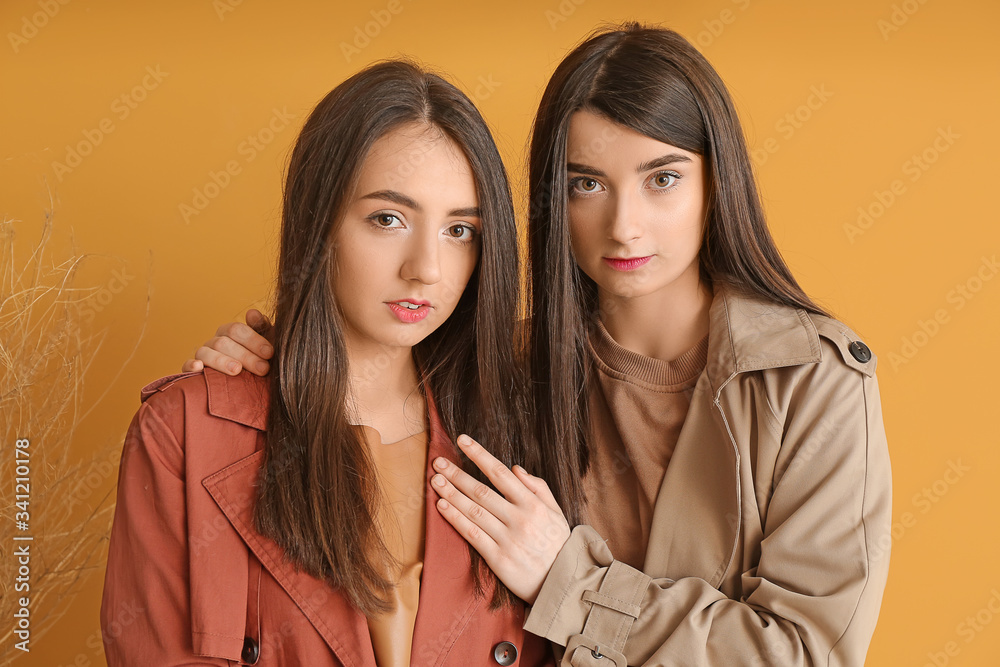 Stylish young women on color background