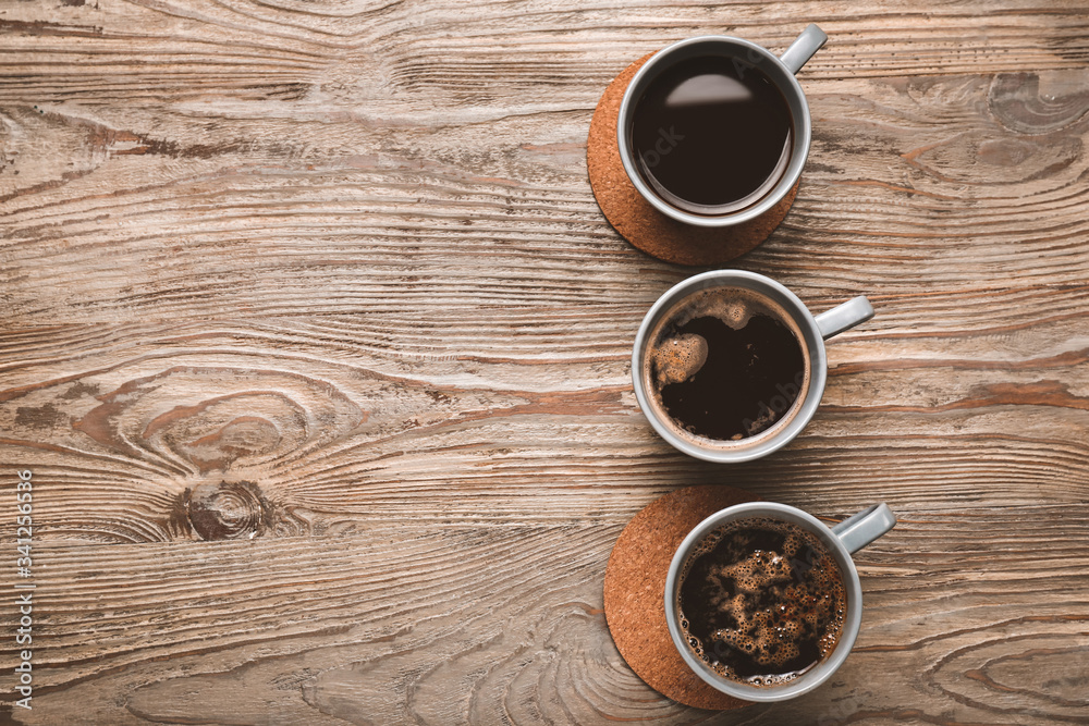 Cups of coffee on wooden background