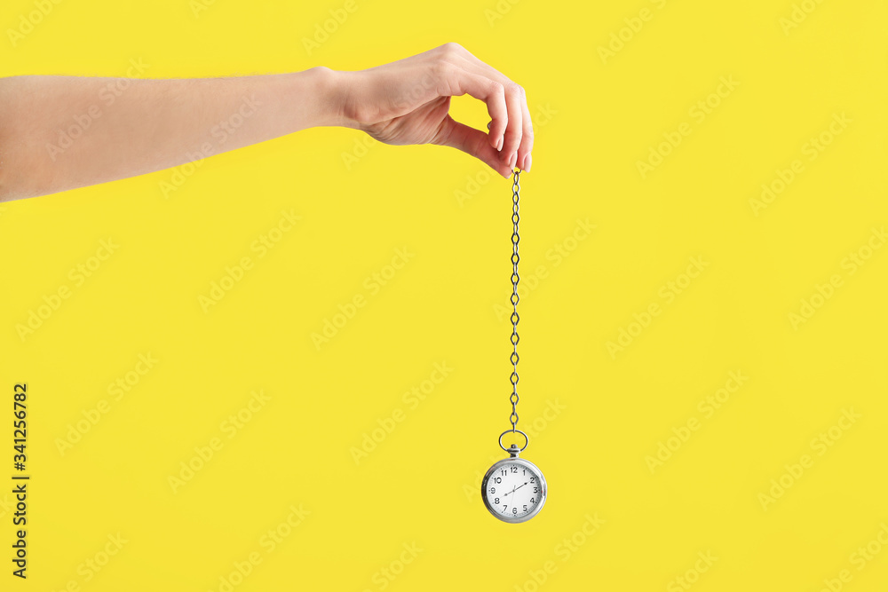 Female hand with pocket clock on color background. Time management concept