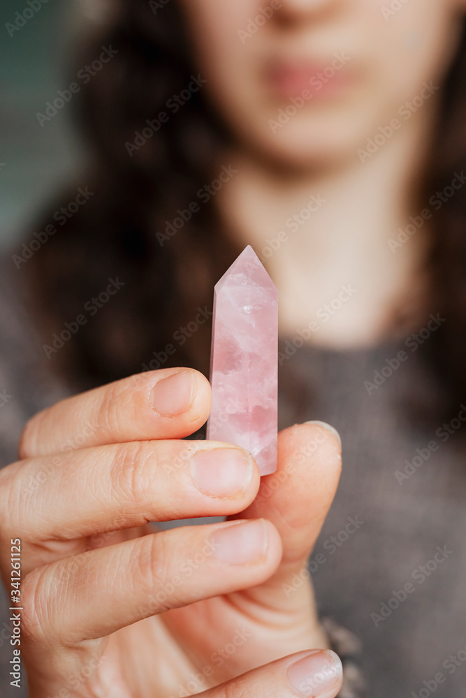 Woman holding a rose quartz crystal