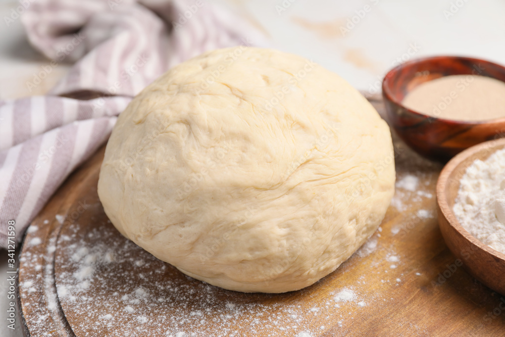 Board with fresh dough on table