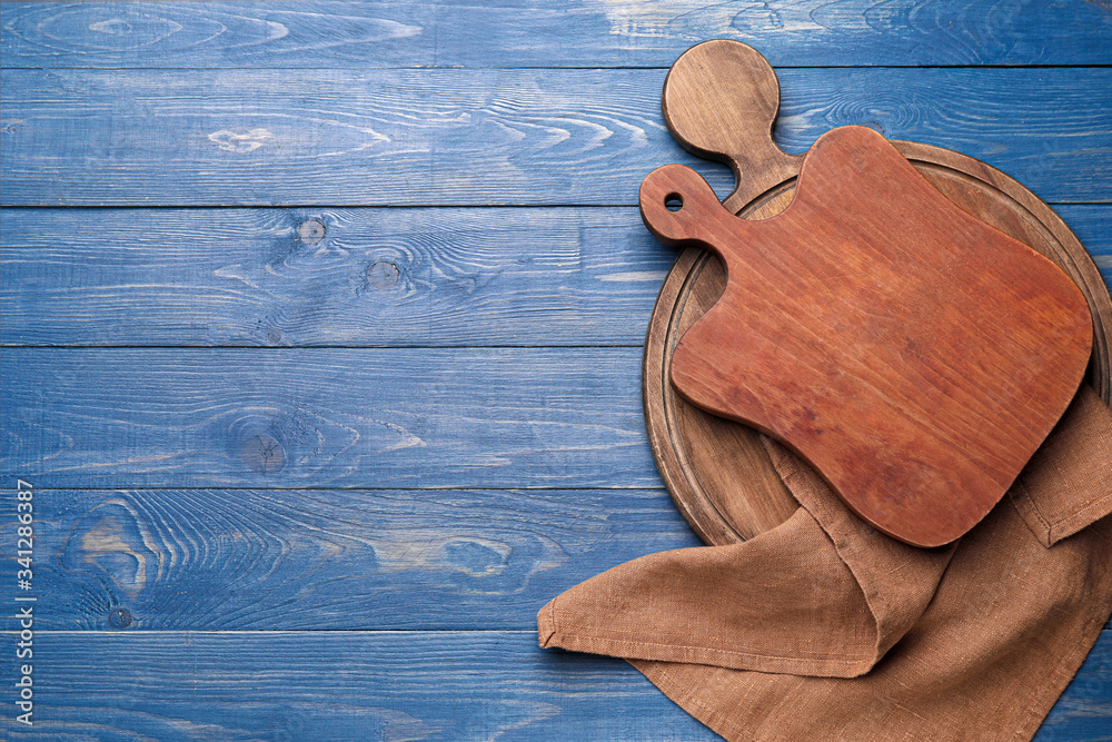 Clean napkin with cutting boards on wooden background