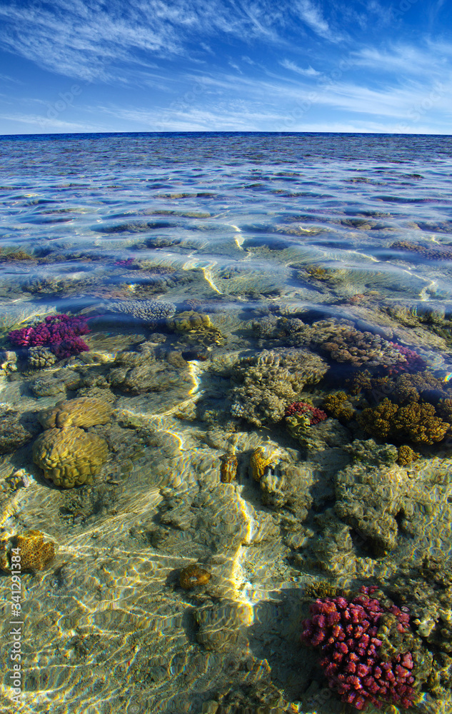 Sea with coral reef and clouds