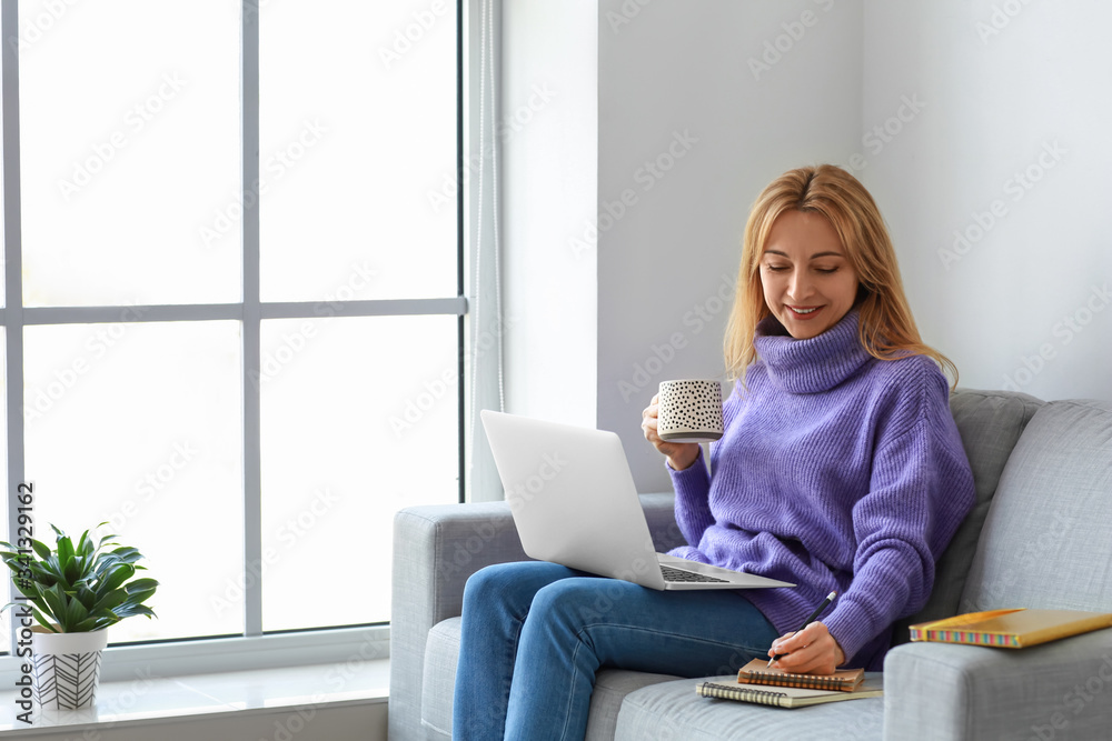 成熟女性在家使用笔记本电脑进行在线学习