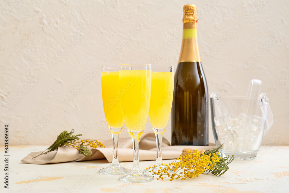 Glasses of tasty mimosa cocktail on white table