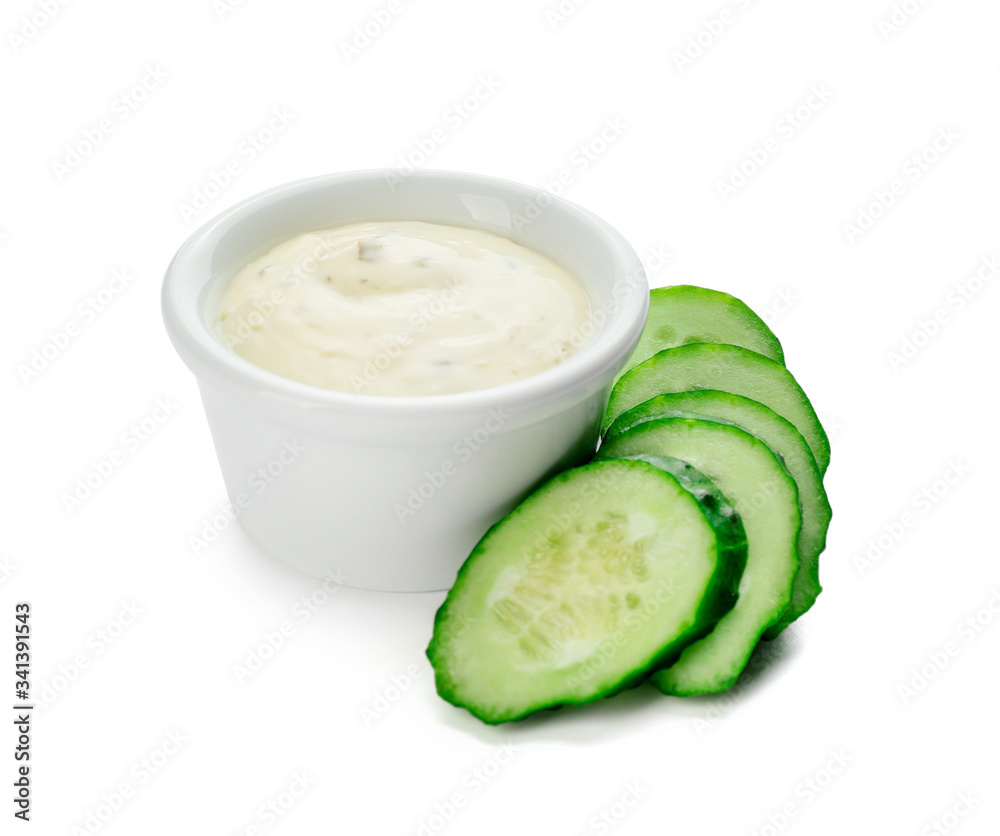 Delicious yogurt sauce with cucumber in bowl on white background