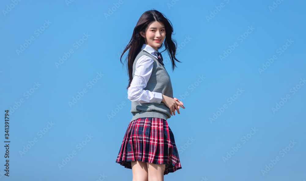 
Asian female students against blue sky background