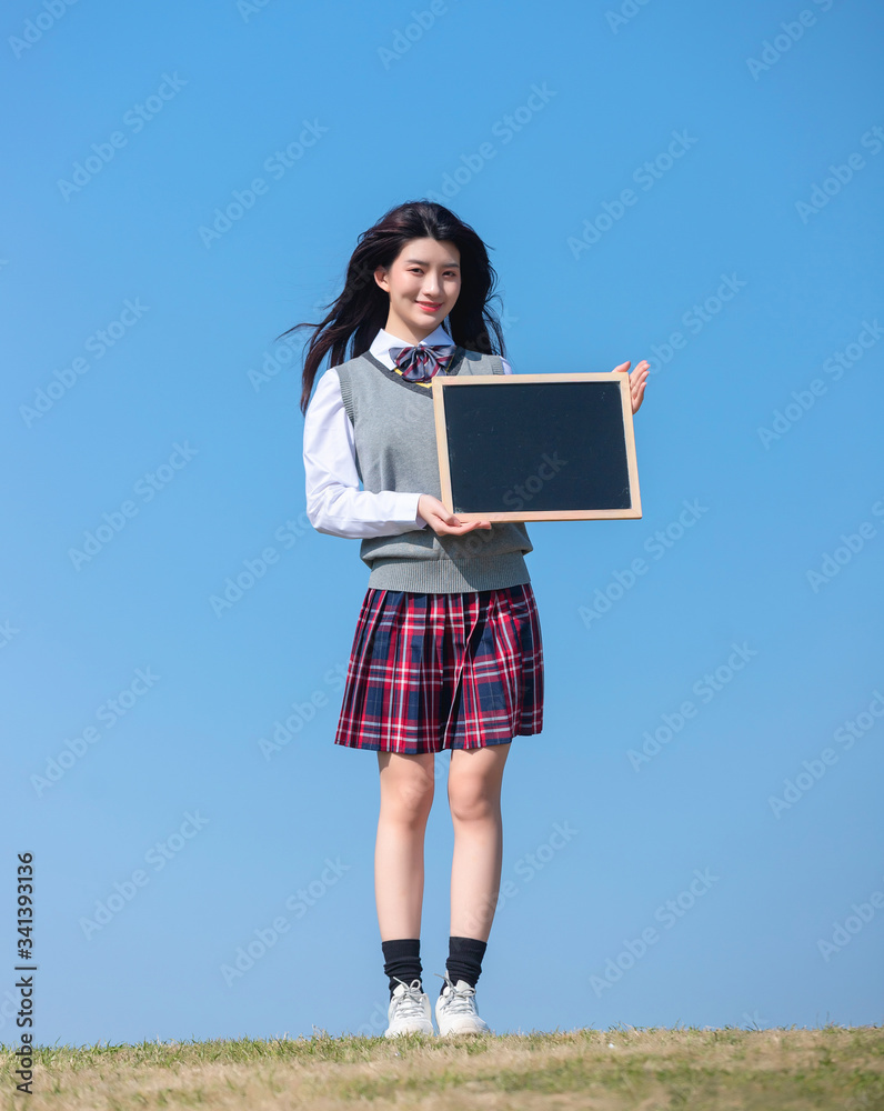 
Asian female students against blue sky background