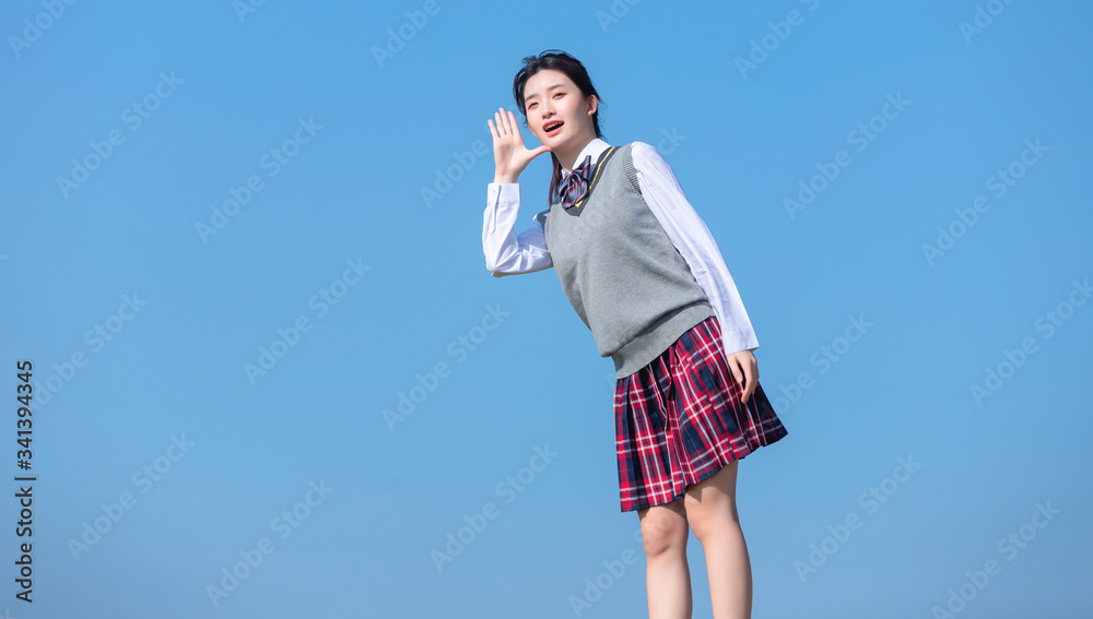 
Asian female students against blue sky background