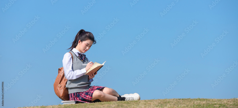 Asian female students against blue sky background