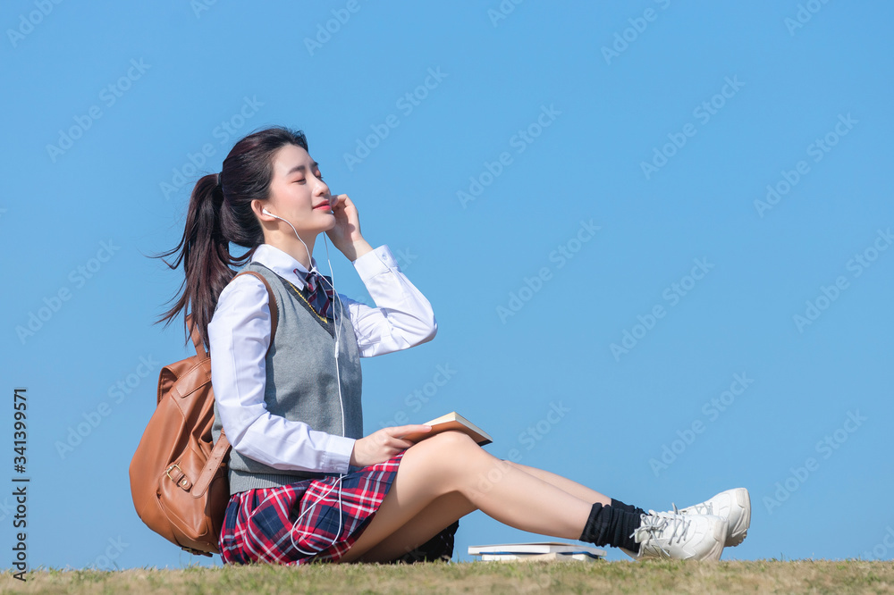 Asian female students against blue sky background