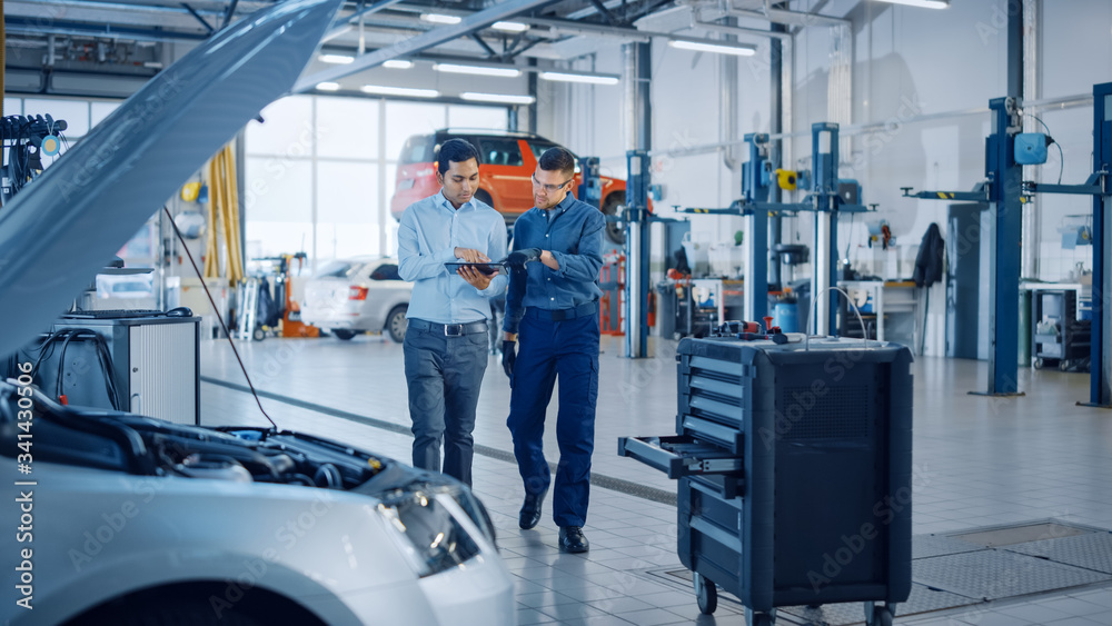 Manager Checks Diagnostics Results on a Tablet Computer and Explains a Vehicle Breakdown to a Handso