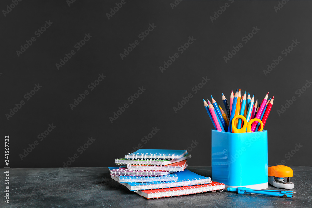 Holder with stationery on dark background