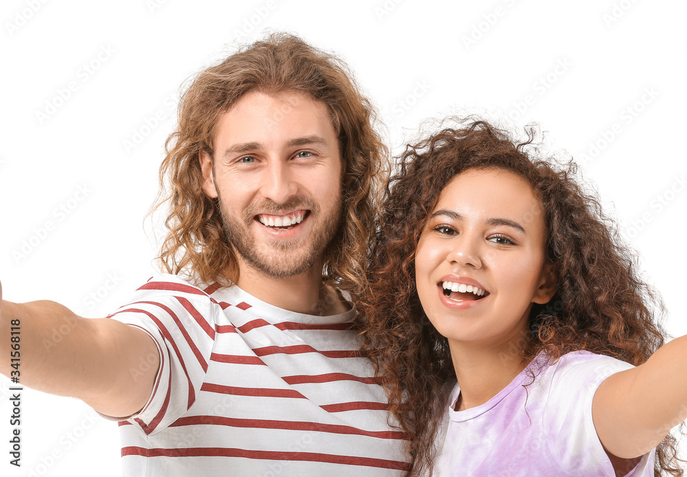 Young couple taking selfie on white background