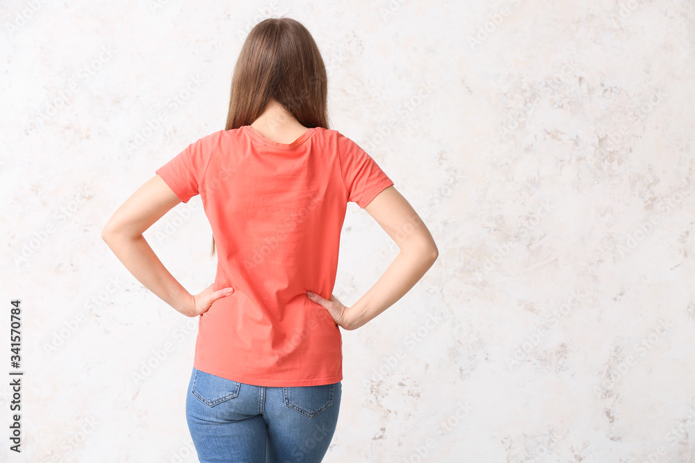 Young woman in stylish t-shirt on light background