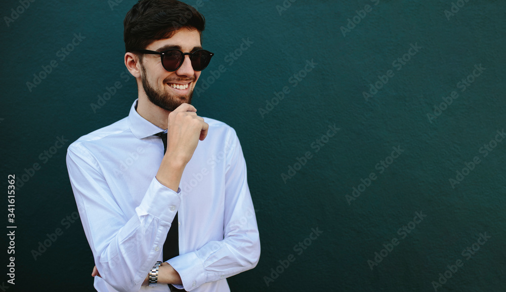 Businessman in sunglasses looking away and smiling