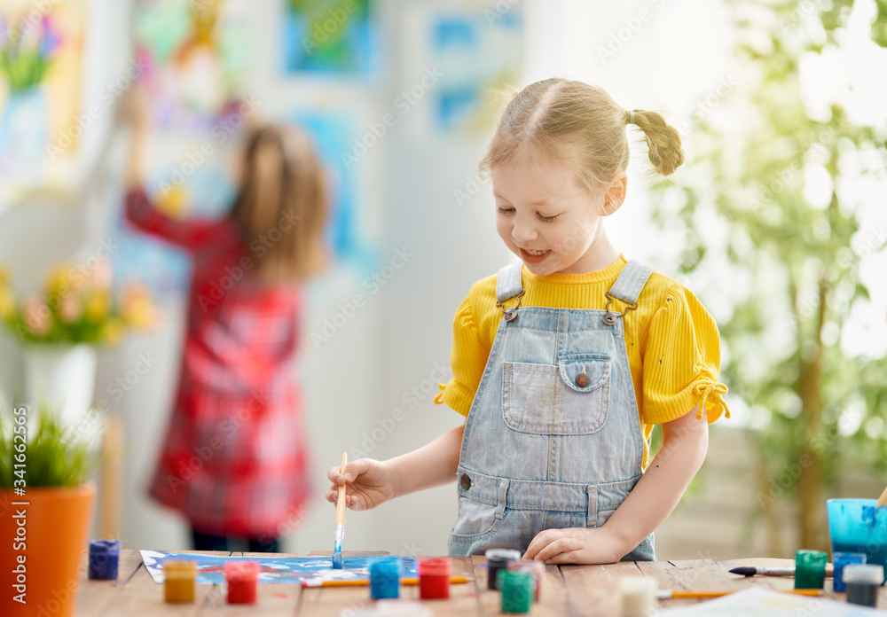 Happy kids are painting at home.