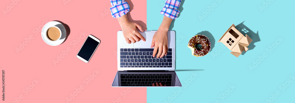 Woman using a laptop computer with a donut and a cup of coffee