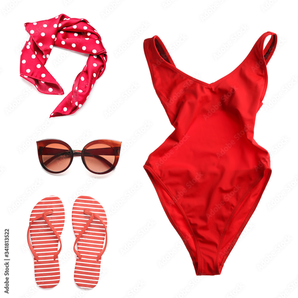 Stylish female swimsuit with accessories on white background